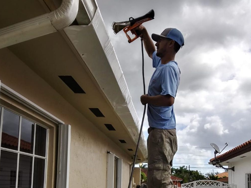 An installer burns the shrink wrap to help seal it to the roof. 